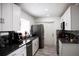Modern kitchen featuring white cabinetry, stainless steel appliances and grey granite countertops at 6508 Lenore Dr, Tampa, FL 33634