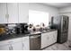Well-lit kitchen with stainless steel appliances, granite countertops, and white cabinets at 6508 Lenore Dr, Tampa, FL 33634