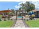 Backyard featuring a sparkling pool, lush landscaping, a cozy cabana, and entertainment area for outdoor enjoyment at 6521 69Th N Ave, Pinellas Park, FL 33781