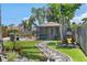 Beautifully landscaped backyard with a pool, lush greenery, stone pathway, and a screened-in seating area at 6521 69Th N Ave, Pinellas Park, FL 33781
