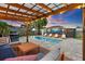 Cozy backyard offers a pool, covered pergola, outdoor seating, and lush landscaping at 6521 69Th N Ave, Pinellas Park, FL 33781
