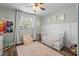 Cozy Bedroom with a neutral color palette features a crib, an armchair, and a plush patterned rug at 6521 69Th N Ave, Pinellas Park, FL 33781