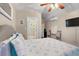 Comfortable bedroom featuring beach themed decor, a ceiling fan, wall mounted TV and an ensuite shower room at 6521 69Th N Ave, Pinellas Park, FL 33781