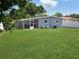 Spacious backyard with lush green grass and a screened in patio ideal for outdoor activities and gatherings at 6527 S West Shore Cir, Tampa, FL 33616