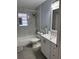 Updated bathroom featuring shower over tub, modern fixtures, gray tiling, and white vanity at 6527 S West Shore Cir, Tampa, FL 33616