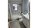 Updated bathroom featuring shower over tub, modern fixtures, gray tiling, and white vanity at 6527 S West Shore Cir, Tampa, FL 33616