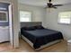 Bright bedroom featuring a ceiling fan, wood flooring, and a gray padded headboard on the bed at 6527 S West Shore Cir, Tampa, FL 33616