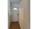 Clean entryway featuring light wood floors, decorative wall paneling and a white door at 6527 S West Shore Cir, Tampa, FL 33616