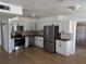 Modern kitchen featuring white cabinets, stainless steel appliances, and stylish backsplash at 6527 S West Shore Cir, Tampa, FL 33616