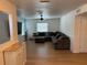Spacious living room featuring light wood floors, a ceiling fan, and a comfortable gray sectional sofa at 6527 S West Shore Cir, Tampa, FL 33616