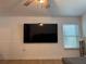 A cozy living room with a large wall-mounted TV, neutral color palette, and ample natural light at 6527 S West Shore Cir, Tampa, FL 33616