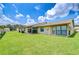 Spacious backyard featuring lush green grass and access to the home at 6550 Teak Ct, Zephyrhills, FL 33542