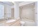 Bright bathroom features granite counters, shower-tub combo, and neutral tile at 6550 Teak Ct, Zephyrhills, FL 33542