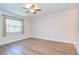 Spacious bedroom featuring a ceiling fan, large window, and light-colored wood flooring at 6550 Teak Ct, Zephyrhills, FL 33542