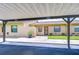 Exterior view under carport showing the unit's entrance, landscaping, and well-kept facade at 6550 Teak Ct, Zephyrhills, FL 33542