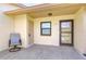 Inviting front entrance with cozy chair, well-lit porch and neutral color scheme at 6550 Teak Ct, Zephyrhills, FL 33542