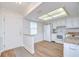 Open kitchen with white appliances, granite countertops, and wood-look flooring, adjacent to the foyer at 6550 Teak Ct, Zephyrhills, FL 33542