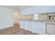 Bright kitchen featuring a countertop, white cabinets, and sleek wooden floors at 6550 Teak Ct, Zephyrhills, FL 33542