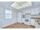 Bright kitchen featuring white appliances and wood flooring at 6550 Teak Ct, Zephyrhills, FL 33542