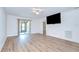 Open-concept living room with wood flooring, ceiling fan, and patio access at 6550 Teak Ct, Zephyrhills, FL 33542