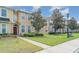 Inviting curb appeal with landscaped lawn and a townhome featuring a red front door at 6920 Towering Spruce Dr, Riverview, FL 33578