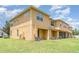 A view of the back exterior of the home with a well-maintained lawn at 6920 Towering Spruce Dr, Riverview, FL 33578