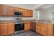 Well-lit kitchen features stainless steel appliances, laminate countertops, and wood cabinets at 6920 Towering Spruce Dr, Riverview, FL 33578