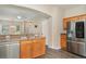 Well-lit kitchen with stainless steel appliances and a bar overlooking living area at 6920 Towering Spruce Dr, Riverview, FL 33578