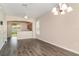 Well-lit living area with dark floors, open to kitchen and view of outdoor space at 6920 Towering Spruce Dr, Riverview, FL 33578