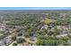 A sprawling residential area is seen from above, with a home featuring a screened pool nestled amongst trees at 709 Grand Canyon Dr, Valrico, FL 33594