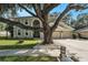 Stunning home exterior with a three car garage and a beautiful tree dominating the front yard at 709 Grand Canyon Dr, Valrico, FL 33594