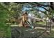 This charming backyard playground includes a slide, swings, and a wooden playhouse for hours of fun at 709 Grand Canyon Dr, Valrico, FL 33594