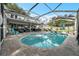 Aerial rear view of backyard pool featuring screened enclosure, patio seating, and brick pool deck at 709 Grand Canyon Dr, Valrico, FL 33594