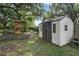 A backyard storage shed stands beside a playground with a slide and swings, providing convenient storage at 709 Grand Canyon Dr, Valrico, FL 33594