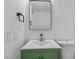 Stylish half-bathroom with a green vanity and modern mirror at 7318 Bellows Falls Ln, Hudson, FL 34667