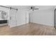 Spacious bedroom featuring modern ceiling fan, plank floors, and stylish barn door to bathroom at 7318 Bellows Falls Ln, Hudson, FL 34667