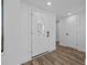 Bright foyer featuring a decorative glass front door and wood-look flooring at 7318 Bellows Falls Ln, Hudson, FL 34667