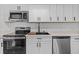 Modern kitchen with stainless steel appliances and white cabinetry at 7318 Bellows Falls Ln, Hudson, FL 34667