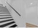Modern staircase featuring black handrail and trim; bright natural light at 7318 Bellows Falls Ln, Hudson, FL 34667