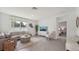 Bright living room with neutral tones, tile floors, and large windows bringing in natural light at 7718 Wheat Stone Dr, Zephyrhills, FL 33540