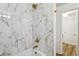 Elegant bathroom with white marble tiled shower, gold fixtures, and tile surround at 800 S Dakota Ave # 204, Tampa, FL 33606