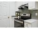 Close up of stove and cabinets in kitchen, with brass fixtures and stainless appliances at 800 S Dakota Ave # 204, Tampa, FL 33606