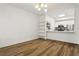 Open-concept living room and kitchen boasts wood floors and white cabinets at 800 S Dakota Ave # 204, Tampa, FL 33606