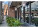 Restaurant exterior featuring large windows and hanging lights surrounded by planters and landscaping at 800 S Dakota Ave # 204, Tampa, FL 33606