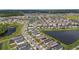 Aerial view of a neighborhood showcases homes with ponds and lush greenery at 8719 Winning Fields Rd, New Port Richey, FL 34655