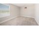 Neutral bedroom features carpet and a window letting in natural light at 8719 Winning Fields Rd, New Port Richey, FL 34655