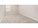 Neutral bedroom features carpet and a window letting in natural light at 8719 Winning Fields Rd, New Port Richey, FL 34655