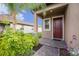 Inviting home entrance with brick walkway, colorful plants, and a striking red front door at 8719 Winning Fields Rd, New Port Richey, FL 34655