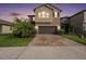 Charming two-story home featuring manicured landscaping, a brick driveway, and a two-car garage at 8719 Winning Fields Rd, New Port Richey, FL 34655