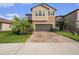 Beautiful two-story home with a brick driveway and lush landscaping, showcasing its inviting facade at 8719 Winning Fields Rd, New Port Richey, FL 34655